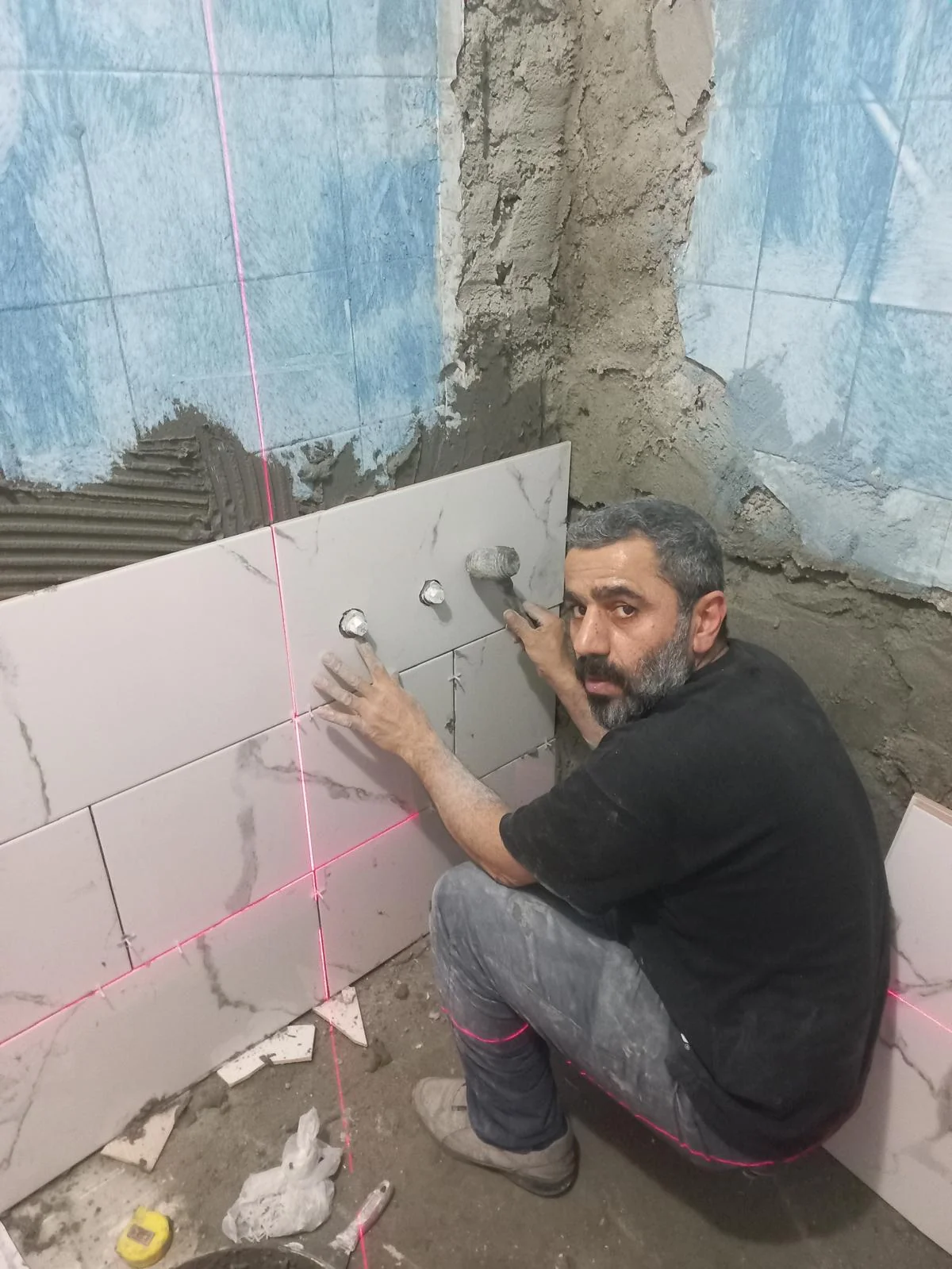 Duvar seramiklerini lazerle hizalayarak yerleştiren Çetinler ekibi